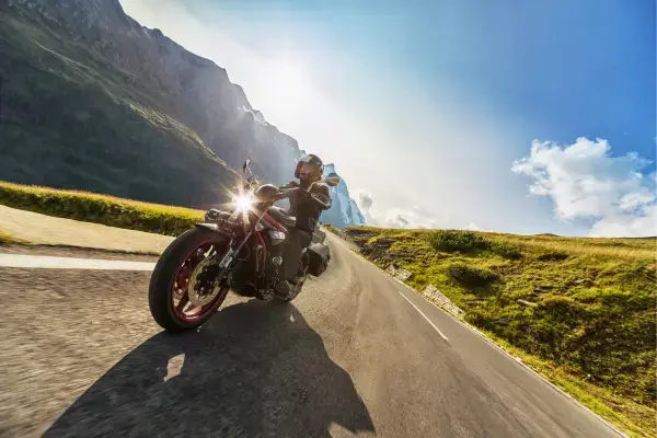 Homem em moto em estrada (Fonte: Canva)
