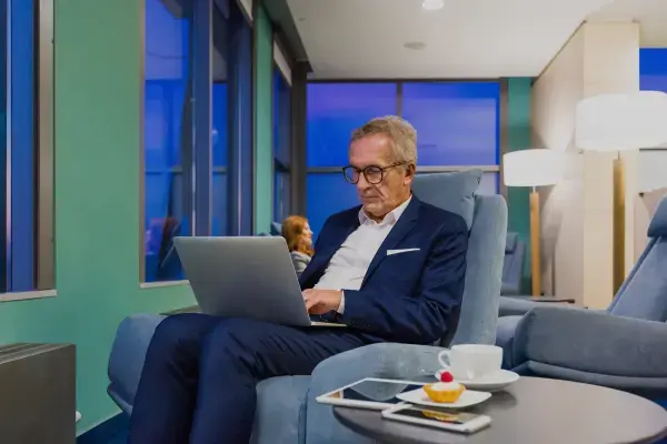 um homem aparentemente da terceira idade com um notebook no colo
