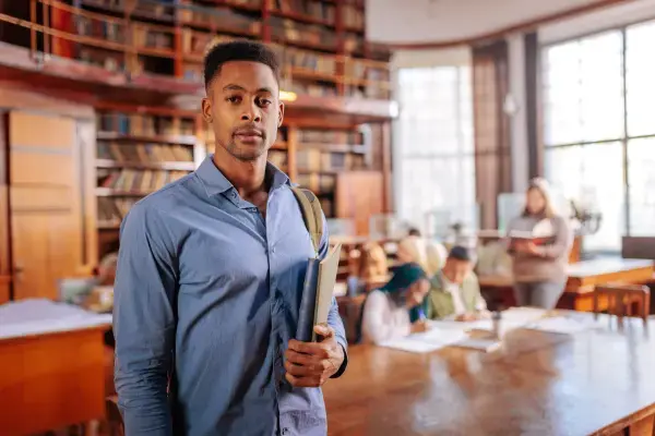 Estudante em biblioteca (Fonte: Canva)