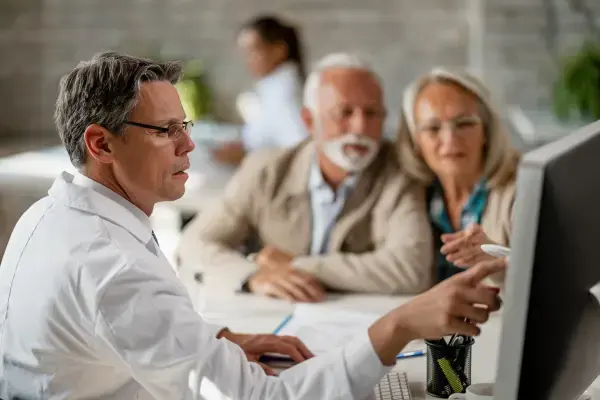 um médico mostrando resultados para pacientes desfocados ao fundo