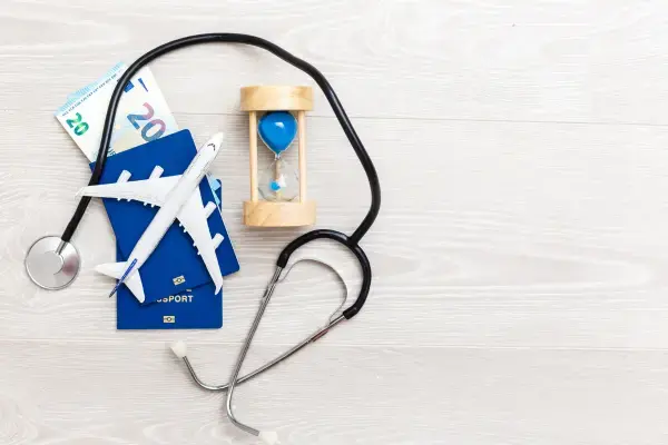Imagem com passaporte, passagens de avião, estetoscópio e outros elementos rementendo ao seguro viagem (Fonte: Canva)