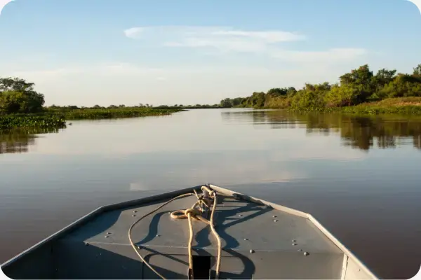 Vista para um rio pelo ponto de vista de quem está em um pequeno barco