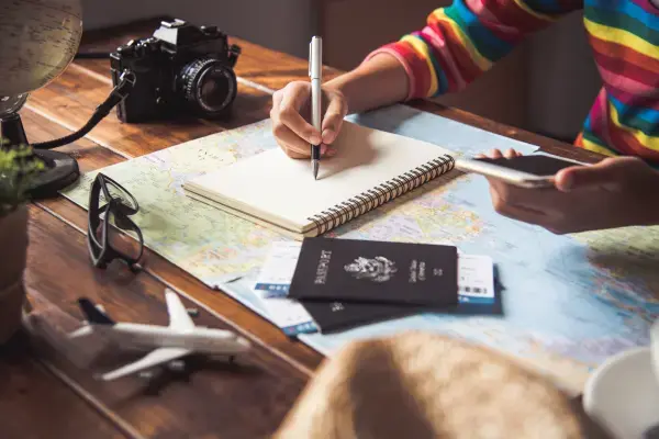 Pessoa fazendo planejamento de viagem (Fonte: Canva)