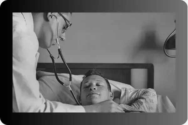 um médico ouvindo a respiração de um paciente deitado