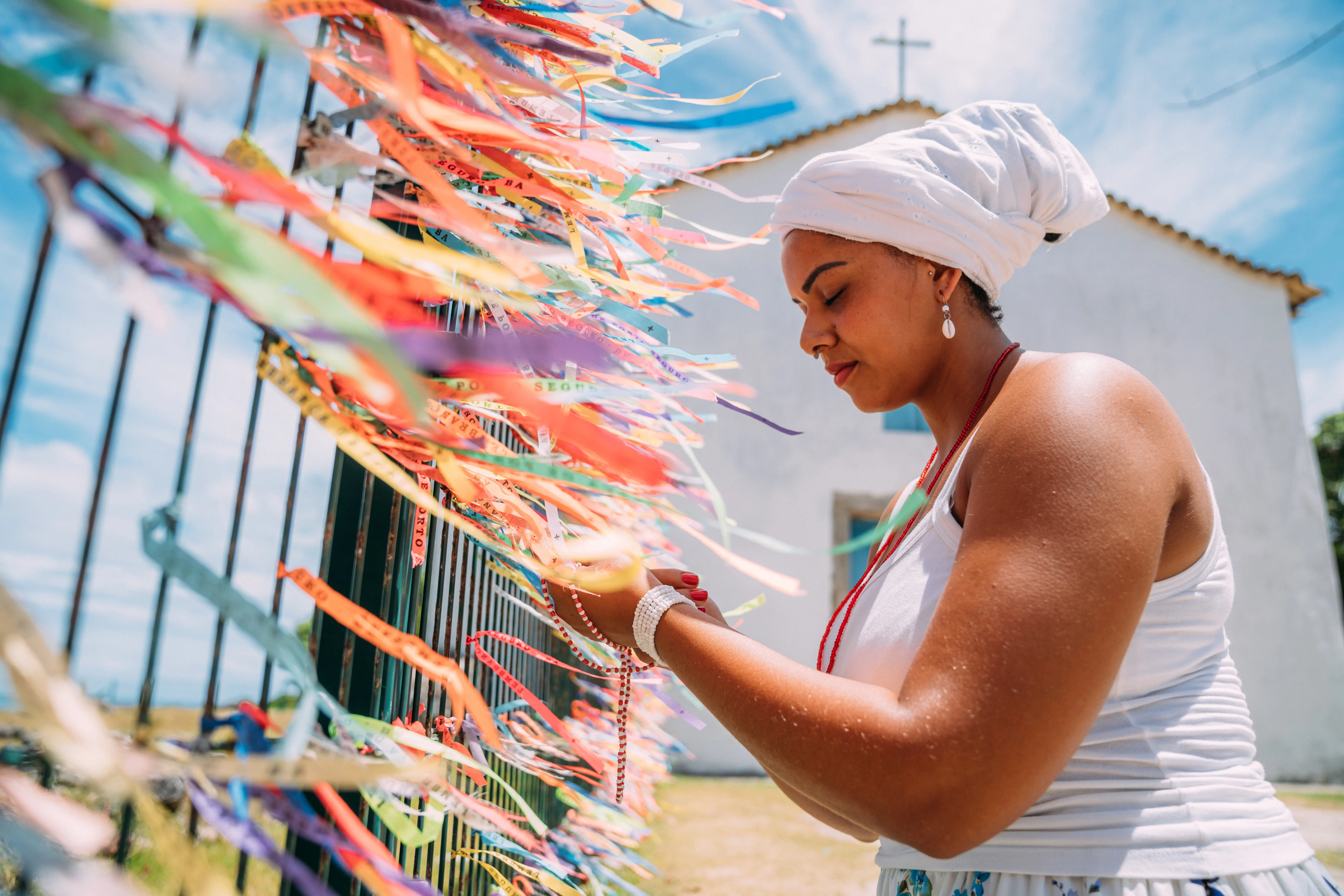 mulher com roupa religiosa orando ao senhor do bonfim