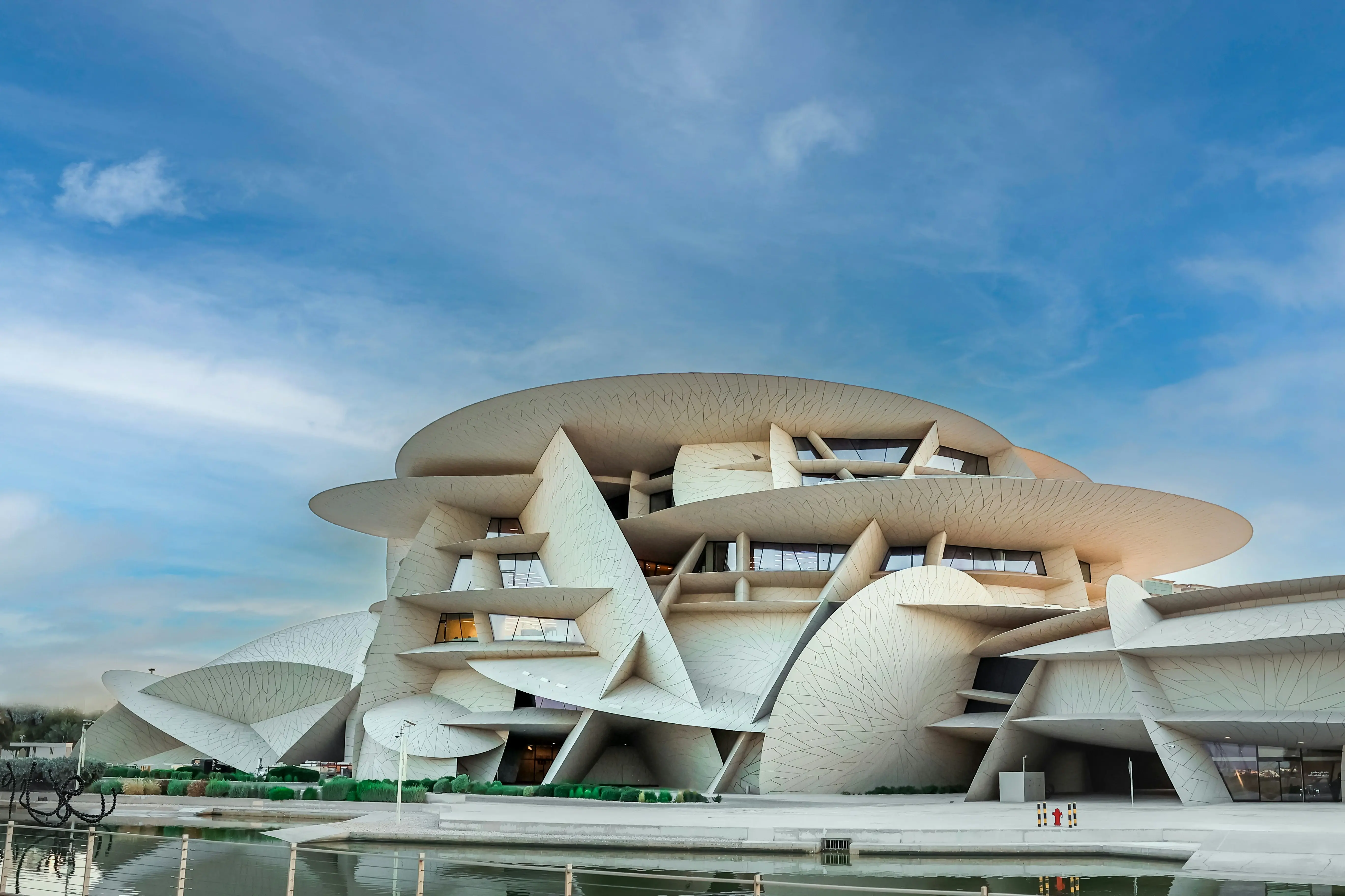 um grande edifício branco sentado ao lado de um corpo d'água