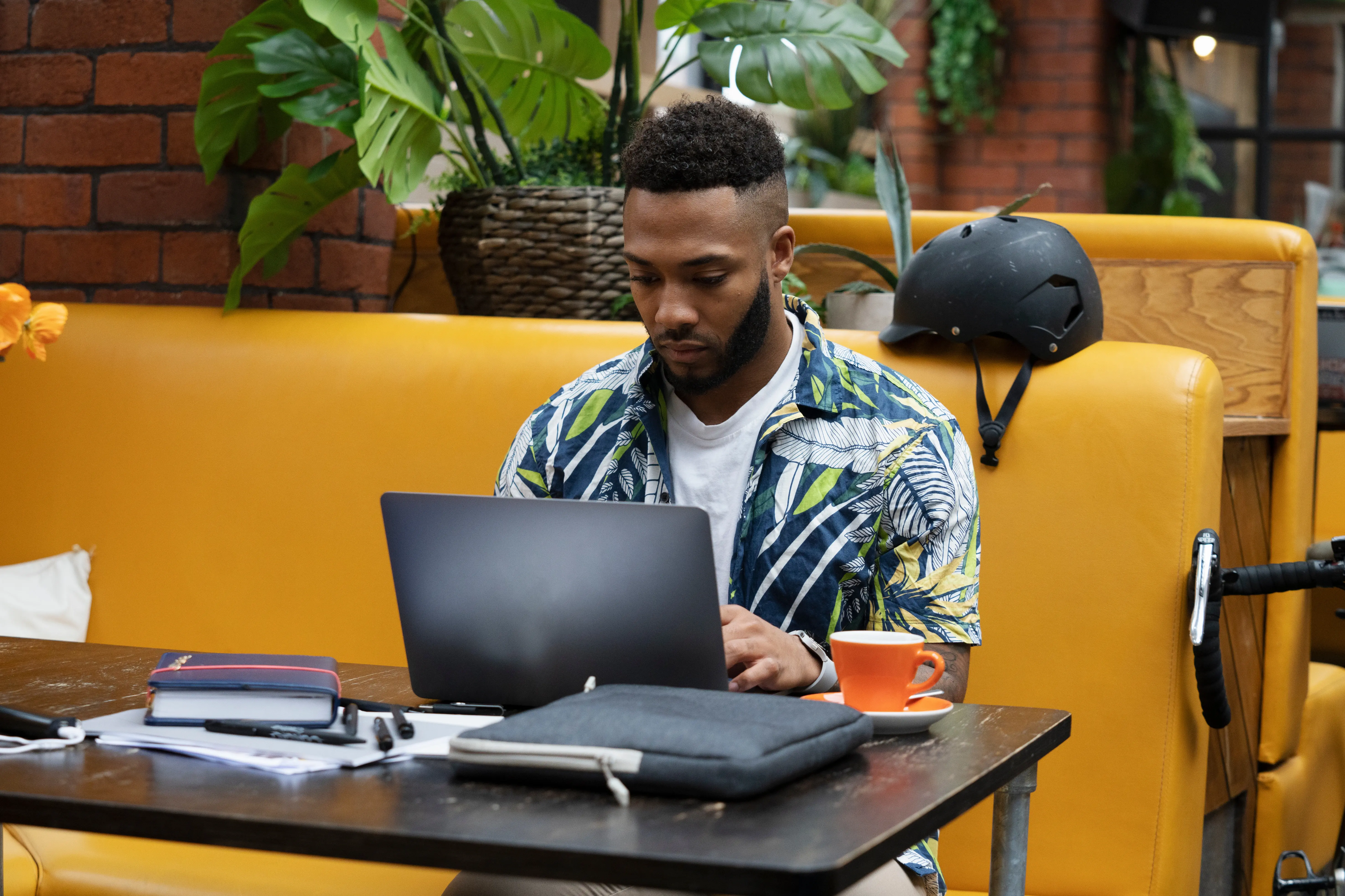 Homem trabalhando com notebook em cafeteria ou coworking (Fonte: Adobe Stock)