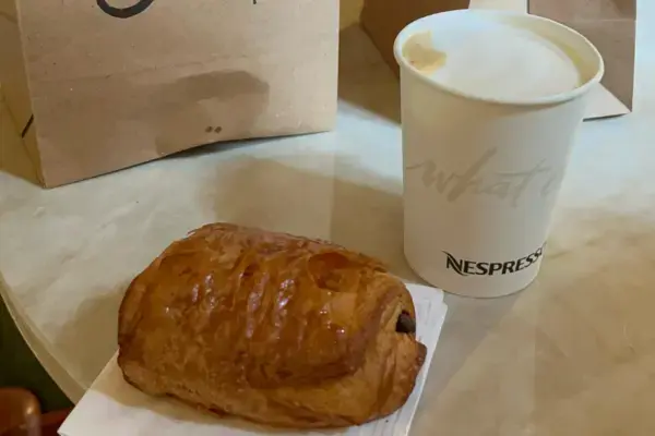 imagem de um café expresso e croassaint em cima da mesa