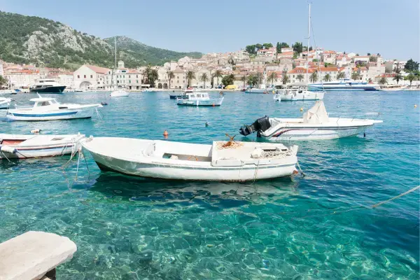 Barcos na água e casas da cidade ao fundo em Hvar, Croácia