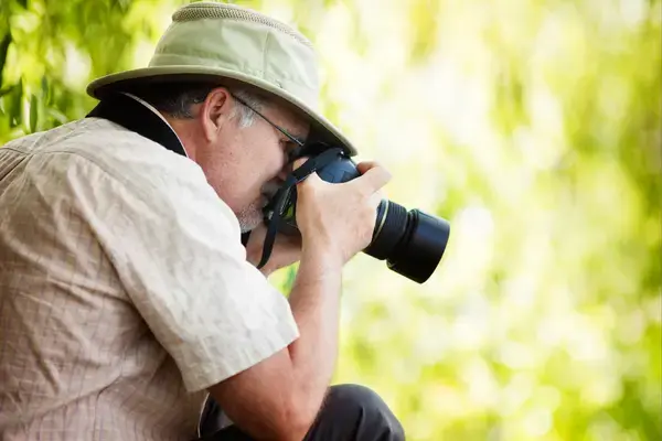 Homem concentrado fotografando a natureza