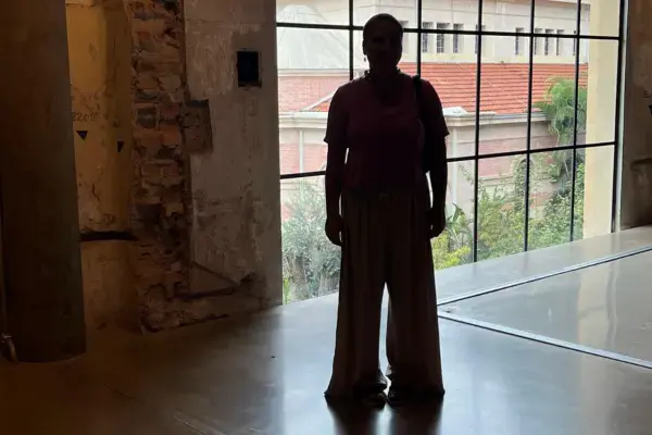 imagem de uma mulher parada em frente a uma janela espelhada de vidro