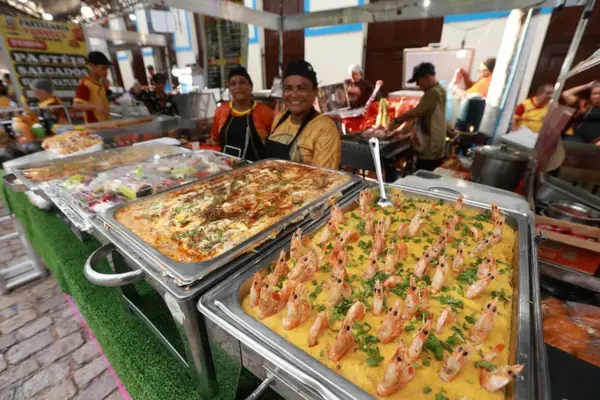 Feira gastronômica do festival com pratos regionais expostos em bandejas.