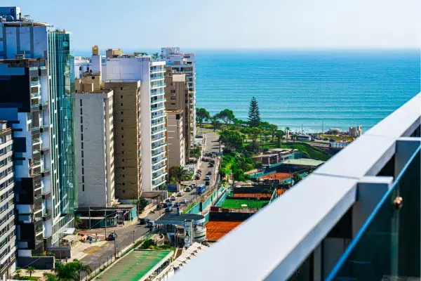 Vista aérea do bairro de Miraflores, em Lima, com prédios modernos e o Oceano Pacífico ao fundo