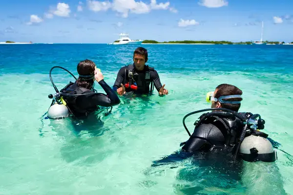 Turistas com equipamentos de mergulho no mar das Bahamas, seguro viagem