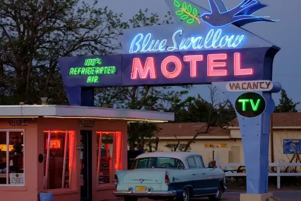 Placa do Blue Swallow Motel iluminada à noite, em Tucumcari, Novo México, na Rota 66.