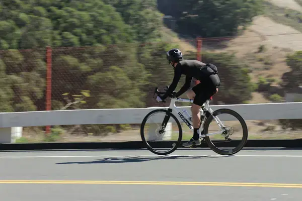 Ciclista pedalando em estrada de montanha durante treino de longa distância
