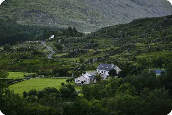 Casa em vale verde cercado por montanhas na Irlanda
