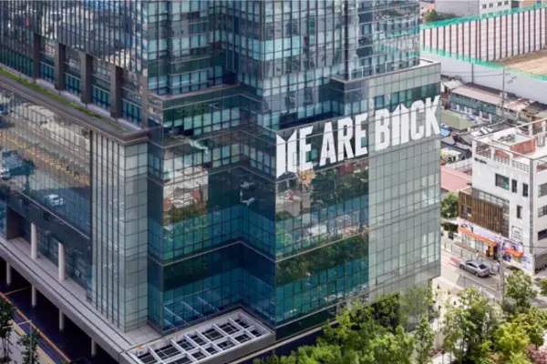 Prédio da HYBE em Seul com o letreiro "We Are Back" na fachada de vidro