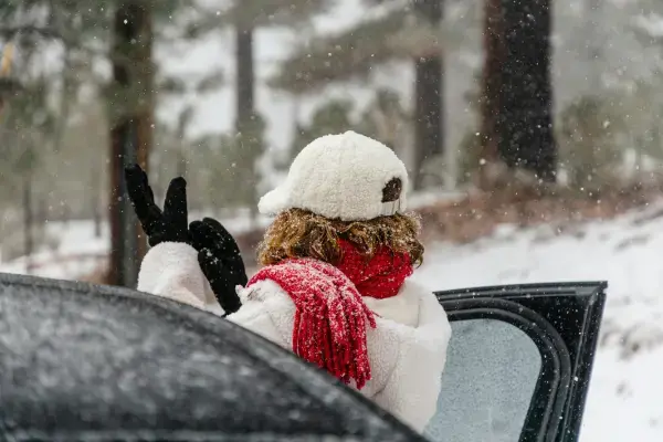 Viajante com casaco, gorro e luvas de inverno em dia de neve