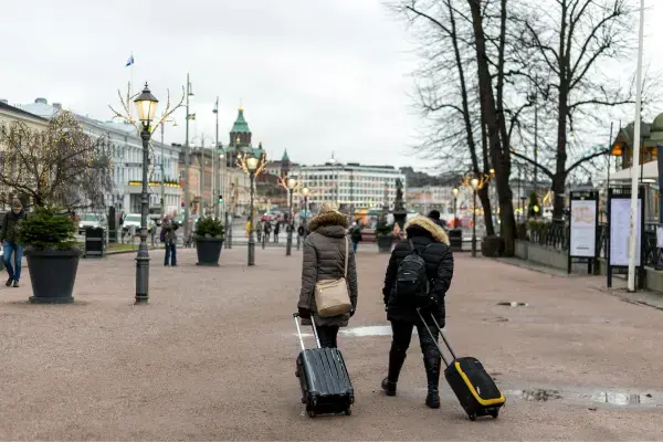 Duas mulheres com malas andando na rua