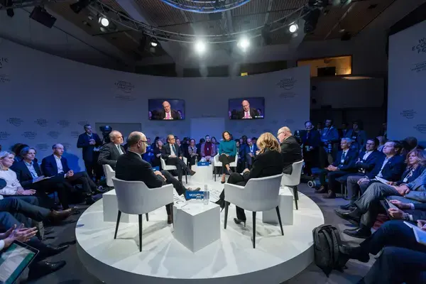 Painel de debate em um congresso corporativo com plateia acompanhando