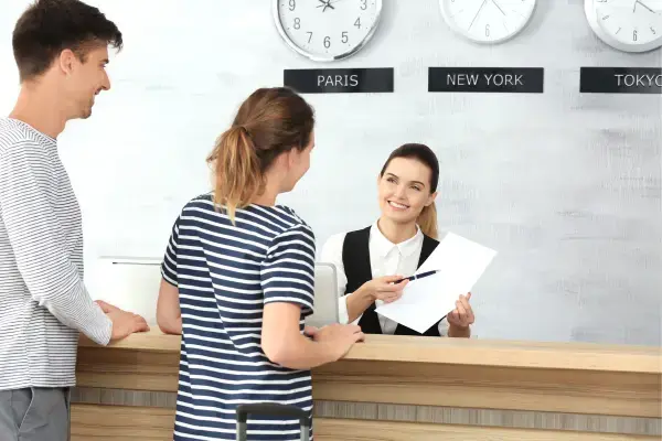 Casal em recepção de hotel (Fonte: Canva)