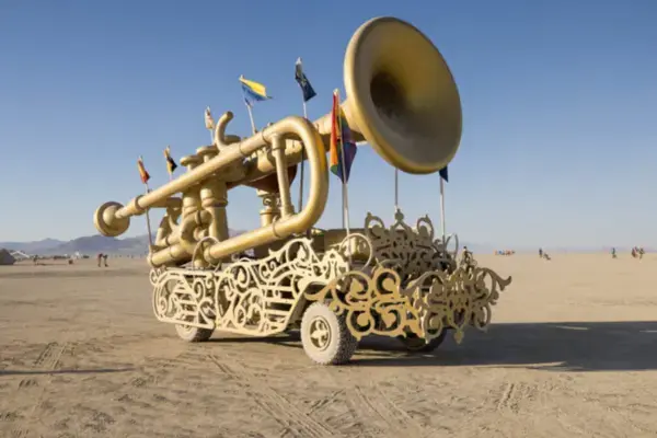 Mutant vehicle em formato de trompete gigante dourado circulando pelo deserto no Burning Man