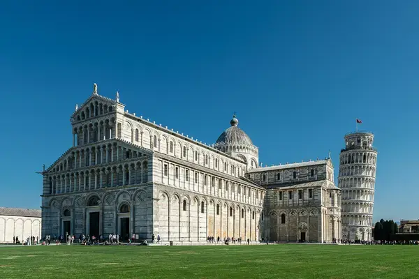 Catedral de Pisa e torre inclinada na Piazza dei Miracoli com turistas no gramado — Toscana