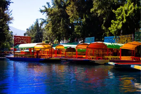 Trajineras coloridas alinhadas nos canais de Xochimilco prontas para passeio.
