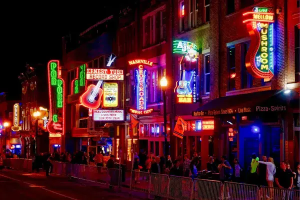 Rua Broadway em Nashville à noite com letreiros neon de bares de música country