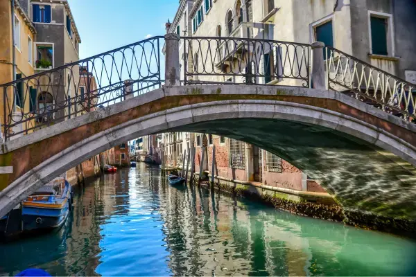Canal de Veneza na primavera, com ponte histórica, água tranquila e céu claro