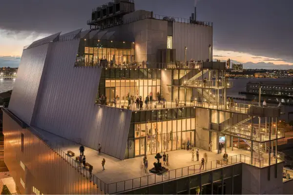Fachada iluminada do Whitney Museum ao entardecer, perto da High Line
