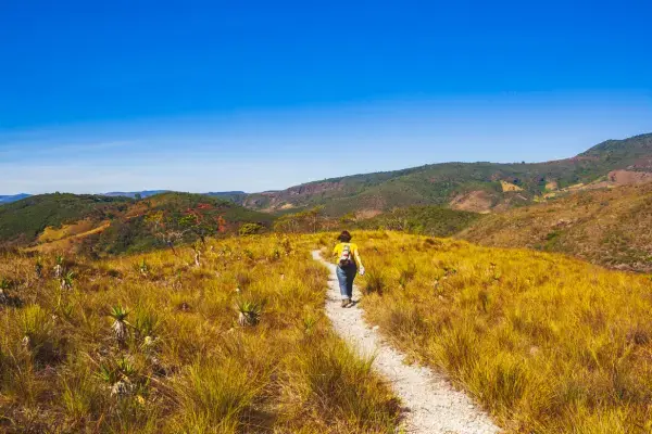 Trilheira caminhando em campo aberto da Serra do Cipó em Santana do Riacho, Minas Gerais