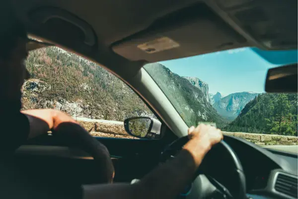 Homem dirigindo com vista para montanhas nos EUA