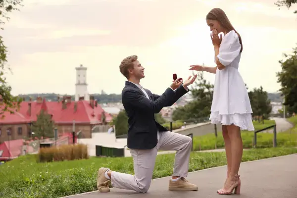 Homem ajoelhado pedindo mulher em casamento (Fonte: Canva)