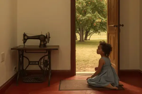 criança no quarto brincando com uma máquina de costura de roda