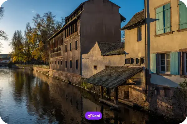 Vista das casas tradicionais em estilo enxaimel no bairro Petite France em Estrasburgo refletidas no canal do rio Ill.)