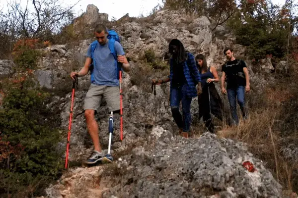 grupo de turistas percorrendo uma trilha com escaladas