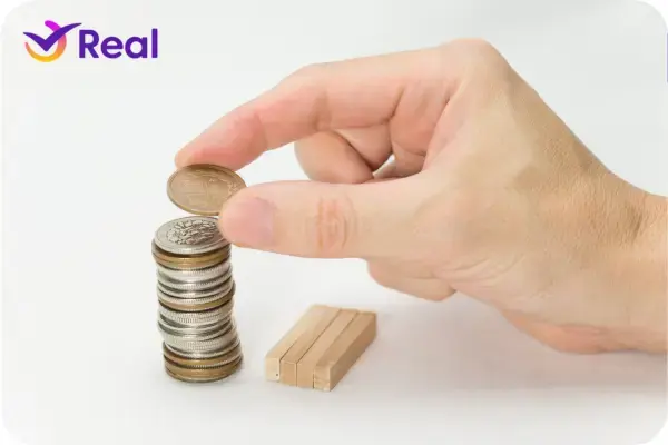 Uma mão empilhando moedas para sua viagem a África