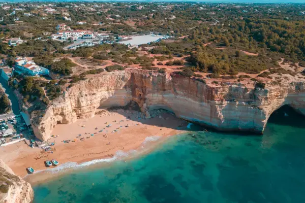 Vista aérea da Praia da Marinha, uma das mais famosas do Algarve, com falésias e mar azul.