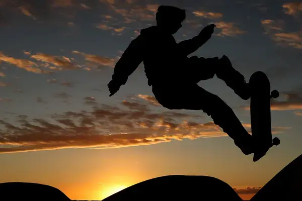 Skatista realizando manobra em pista de skate ao ar livre.