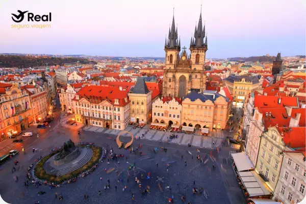 Fachada do Relógio Astronômico na Praça da Cidade Velha em Praga, com turistas reunidos em frente.