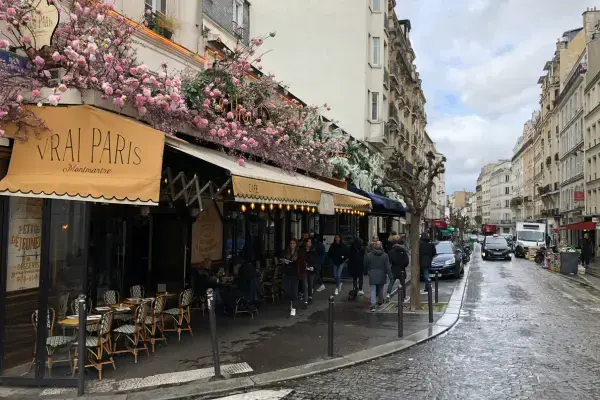 Rua de Montmartre em Paris na primavera, com cafés, flores e movimento urbano