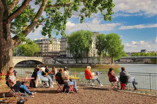 Pessoas aproveitando o verão às margens do Rio Sena em Paris