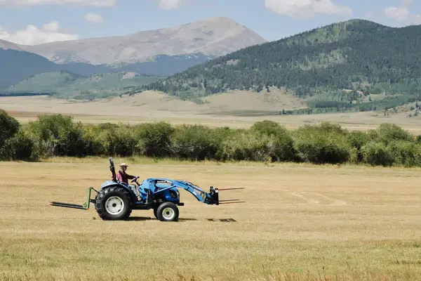Homem dirigindo trator em ambiente rural