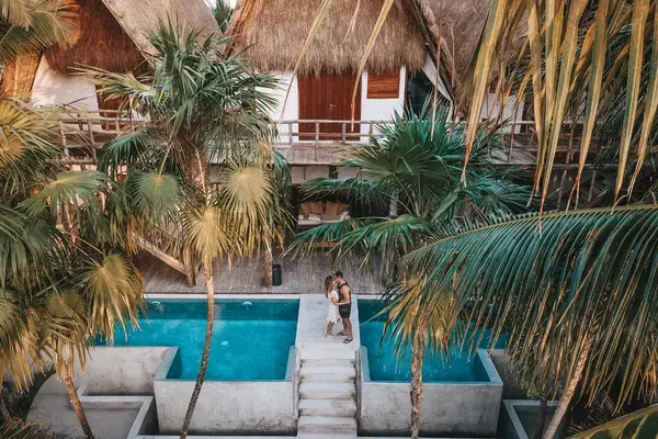 Casal em hospedagem tropical com piscinas privativas para lua de mel.