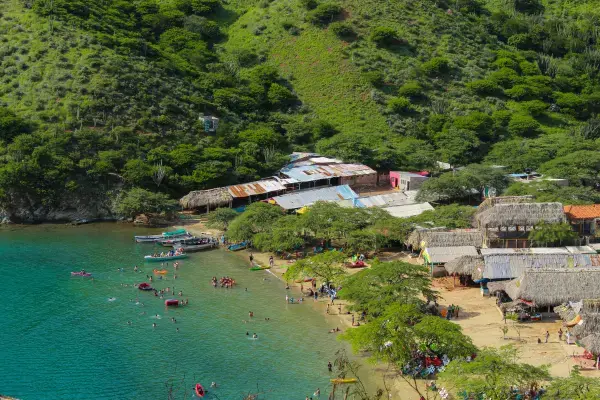 Vista aérea da baía de Taganga com turistas, barcos e vegetação tropical na costa colombiana