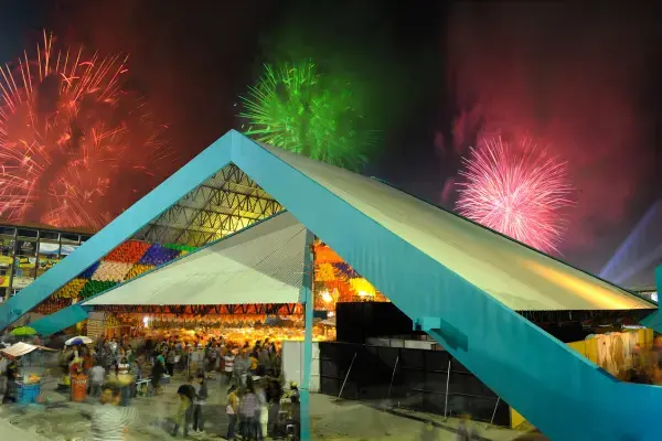 Fogos de artifício sobre o pavilhão de uma grande festa junina à noite
