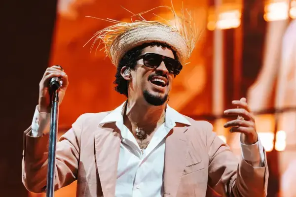 Bad Bunny se apresentando no palco com chapéu de palha durante show em 2026