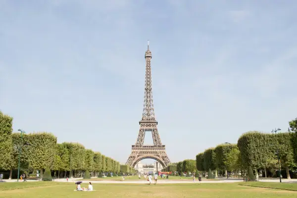 Torre Eiffel vista do Champ de Mars em dia de verão com céu azul